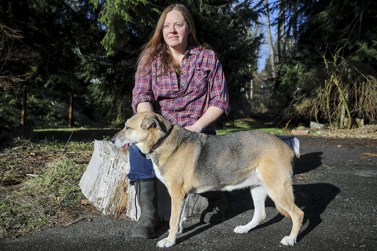 Elaine Kellner, 42, poses for a photo with her dog Penny at Hearth and Haven Farm in Monroe, Washington on Wednesday, Jan. 11, 2023. The farm lost its entire flock of 170 ducks and four geese to avian flu. (Annie Barker / The Herald)