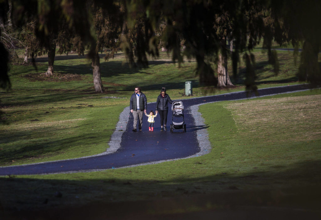 A family walks along a new paved path Tuesday through Ballinger Parkin Mountlake Terrace. (Olivia Vanni / The Herald)
