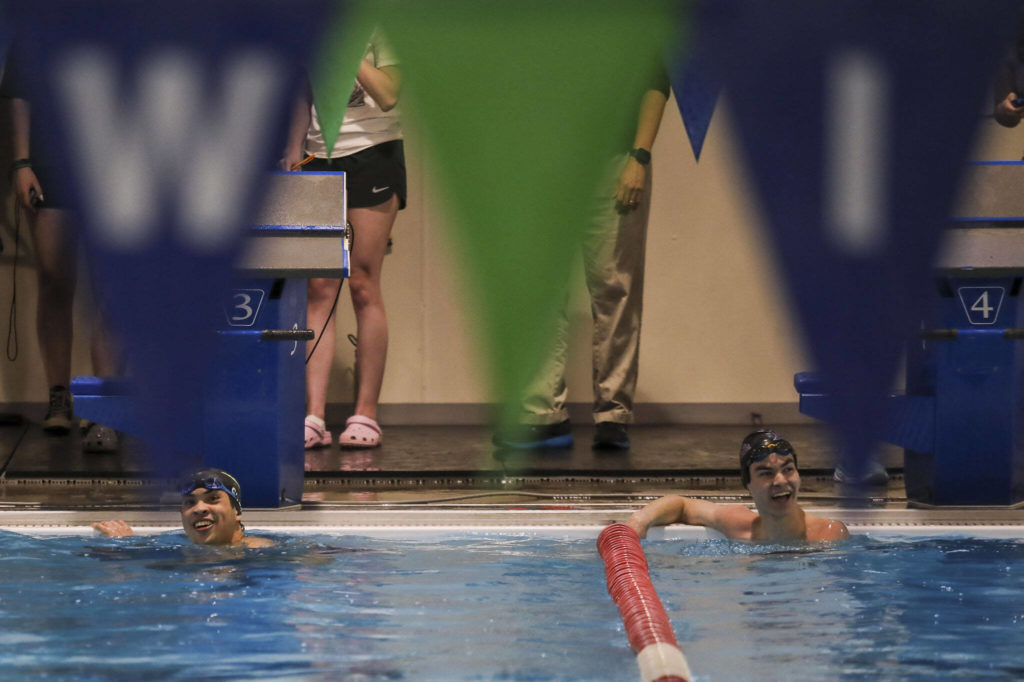 Jackson’s Ethan Chen-Park, left, and Kamiak’s Jack Fast, right, react after placing first and second in the fifth heat of the 50 yard freestyle race during the Jackson vs. Kamiak boys swim and dive meet at West Coast Aquatics in Mill Creek, Washington on Tuesday Jan. 10, 2023. (Annie Barker / The Herald)
