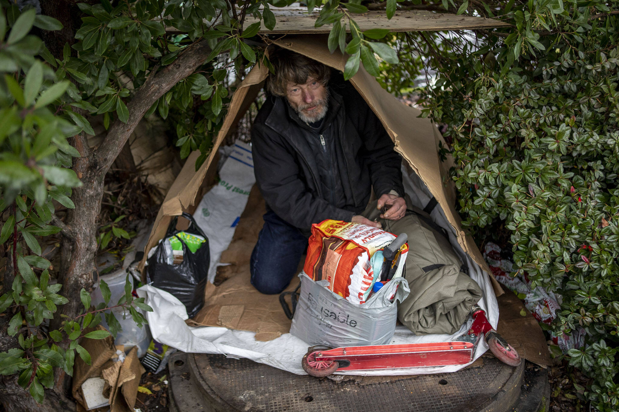 Mel Jennings sits in his structure during a point-in-time count of people facing homelessness on Tuesday, in Everett. Mel has had a brain and spinal surgery, and currently has been homeless for a year. (Annie Barker / The Herald)