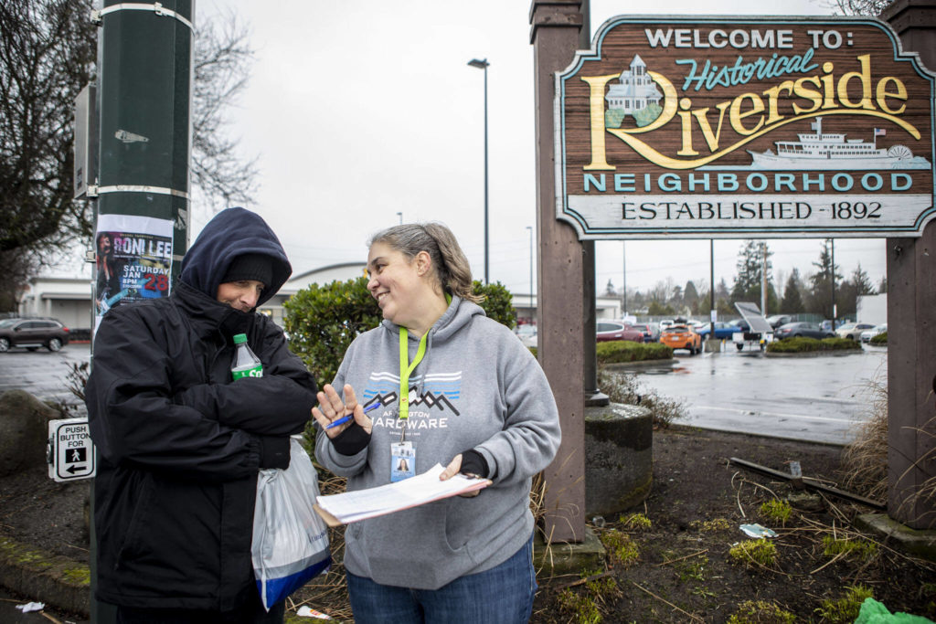 Catholic Community Services NW Director of Housing Services and Everett Family Center Director Rita Jo Case, right, speaks to Jason Browning, left, during a point-in-time count of people facing homelessness on Tuesday, in Everett. Browning sometimes stays along Casino Road and tries to help clean up after others in the area. (Annie Barker / The Herald)
