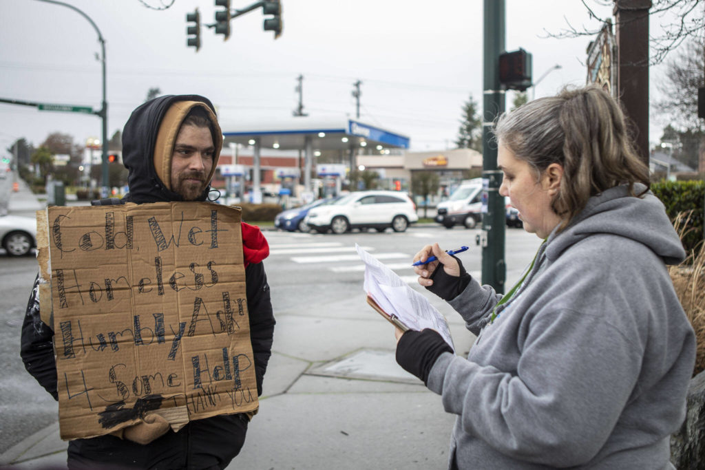 Catholic Community Services NW Director of Housing Services and Everett Family Center Director Rita Jo Case, right, speaks to a man who asked to remain anonymous, left, during a point-in-time count of people facing homelessness on Tuesday, in Everett. (Annie Barker / The Herald)
