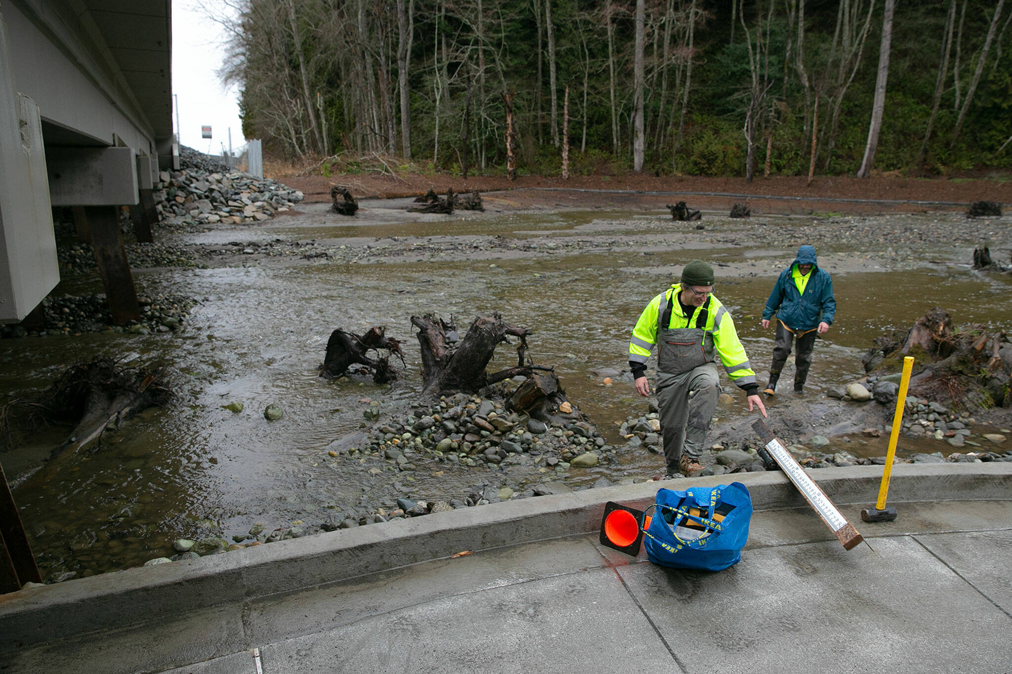 John Herrmann and Keith Hume, both of the Surface Water Management team at the Snohomish County Department of Conservation and Natural Resources, prepare to install a staff gauge at the mouth of Lunds Gulch Creek at Meadowdale Beach Park on Jan. 12, in Edmonds. Part of the park’s redesign involved widening the waterway and returning it to a more natural state to provide better habitat for fish and other wildlife. (Ryan Berry / The Herald)