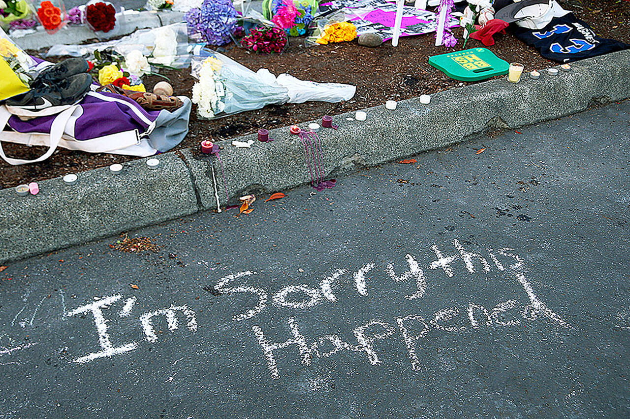 Messages are left at a memorial in the parking lot of Kamiak High School, July 31, 2016, after a community vigil for the victims of a shooting that occurred early that morning at a home in Mukilteo, killing three Kamiak High School graduates and wounding a fourth. (Genna Martin / Associated Press file photo)