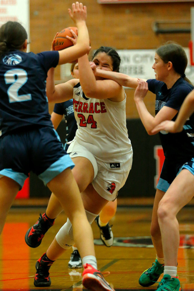 Mountlake Terrace’s Maya Davis gets fouled while trying to split the Meadowdale defense on Wednesday, Jan.11, 2023, at Mountlake Terrace High School in Mountlake Terrace, Washington. (Ryan Berry / The Herald)
