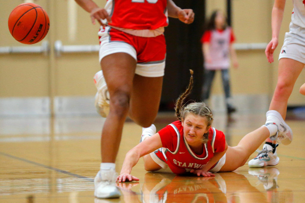 Stanwood’s Ava Depew hits the floor after being fouled in transition against Snohomish on Friday, Jan. 13, 2023, at Snohomish High School in Snohomish, Washington. (Ryan Berry / The Herald)
