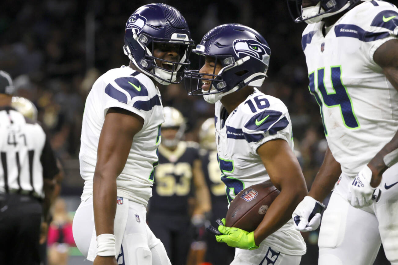 Seattle Seahawks quarterback Geno Smith, left, celebrate his touchdown pass to wide receiver Tyler Lockett during an NFL football game against the New Orleans Saints in New Orleans, Sunday, Oct. 9, 2022. (AP Photo/Derick Hingle)