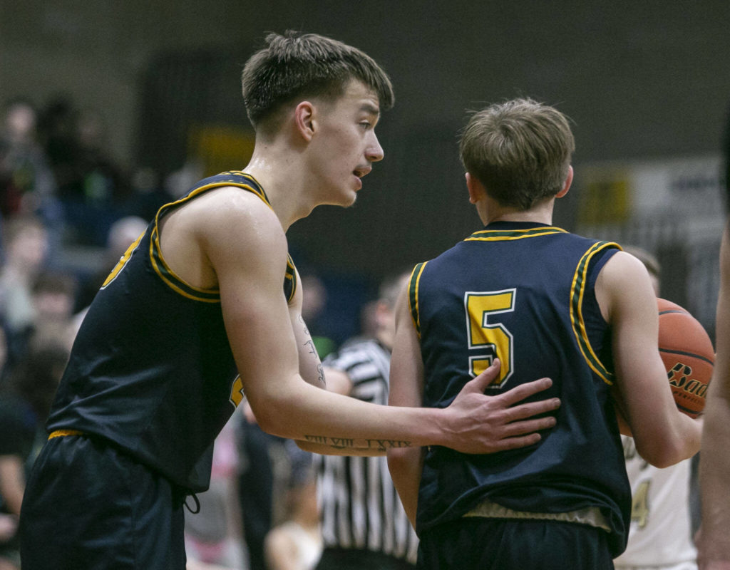 Shorecrest’s Parker Baumann talks to his teammate Brayden Fischer during the game against Arlington on Thursday, Jan. 19, 2023 in Arlington, Washington. (Olivia Vanni / The Herald)
