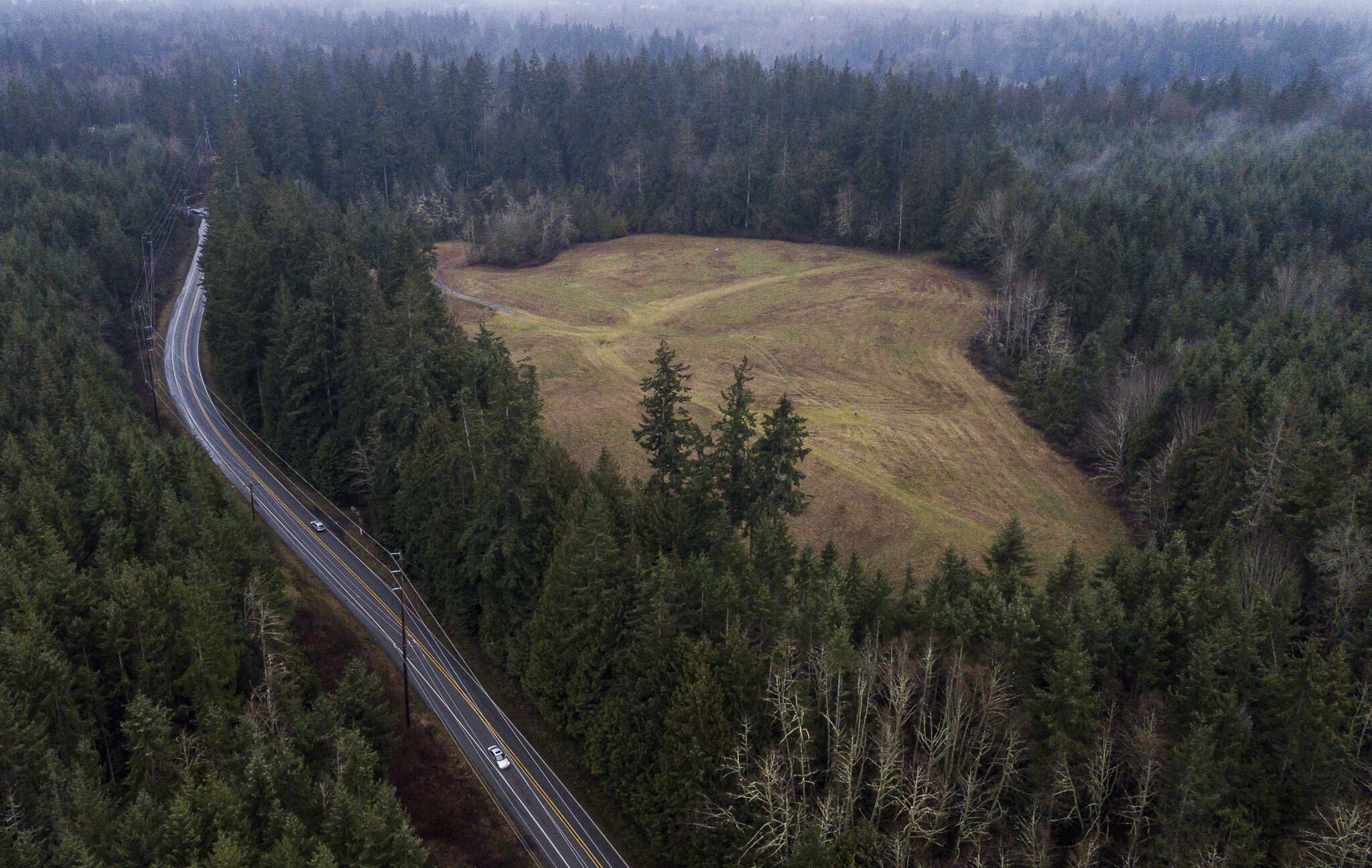 Cars move along Frank Waters Road next to a contaminated land site purchased by Robinett Brothers on Tuesday, in Stanwood. (Olivia Vanni / The Herald)