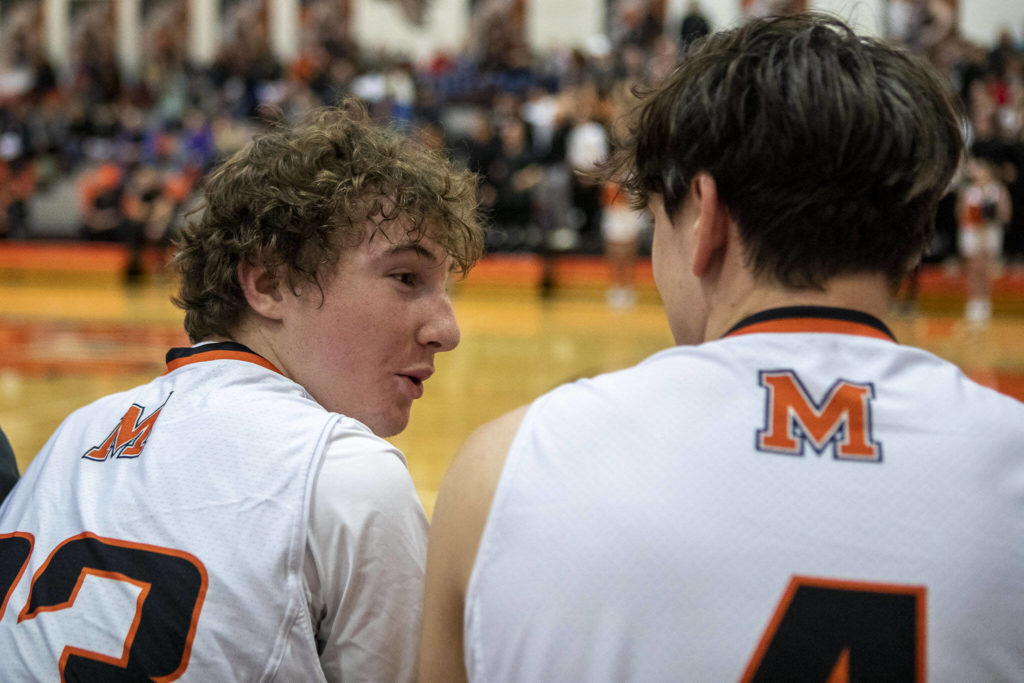 Monroe’s Lucas McCullough (23), left, reacts with Eli Miller (4) during a game between the Monroe Bearcats and the Edmonds-Woodway Warriors at Monroe High School in Monroe on Jan. 20. The Bearcats defeated the Warriors, 68-57. (Annie Barker / The Herald)
