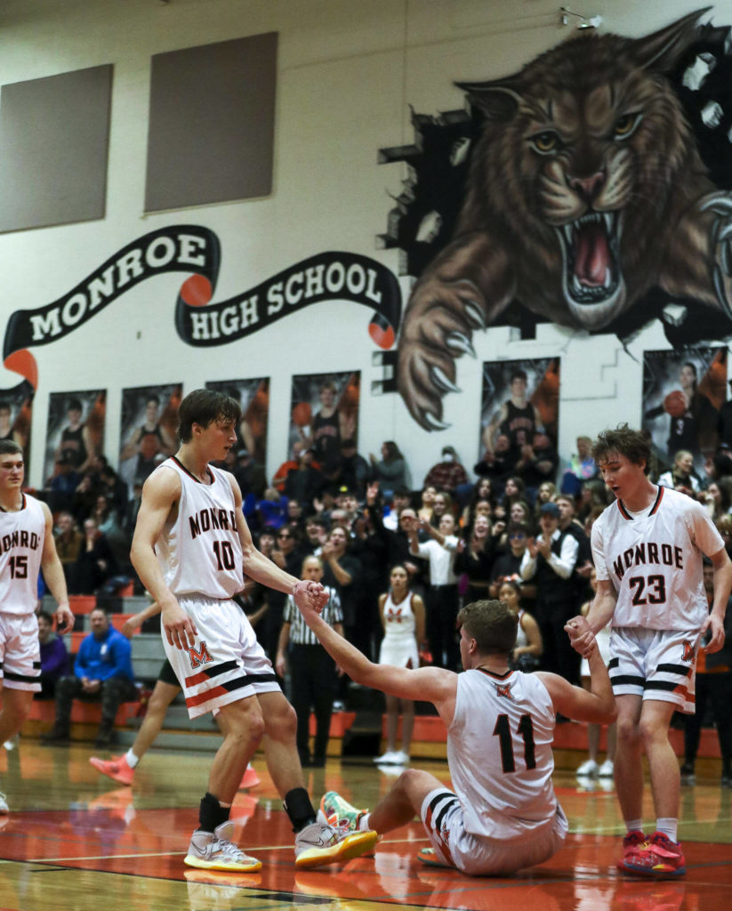 Monroe’s Reid Schaeffer (11) is helped up by his teammates during a game between the Monroe Bearcats and the Edmonds-Woodway Warriors at Monroe High School in Monroe, on Jan. 20. The Bearcats defeated the Warriors, 68-57. (Annie Barker / The Herald)
