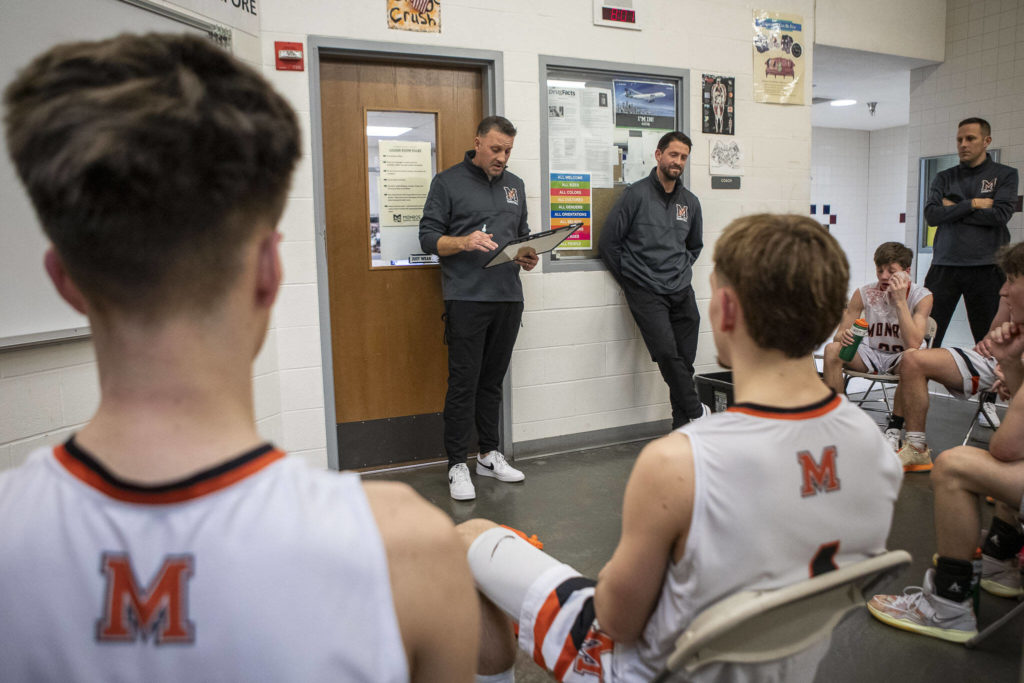 Head coach Justin Prohn, writes notes and gives feedback at halftime during a game between the Monroe Bearcats and the Edmonds-Woodway Warriors at Monroe High School in Monroe, on Jan. 20. The Bearcats defeated the Warriors, 68-57. (Annie Barker / The Herald)
