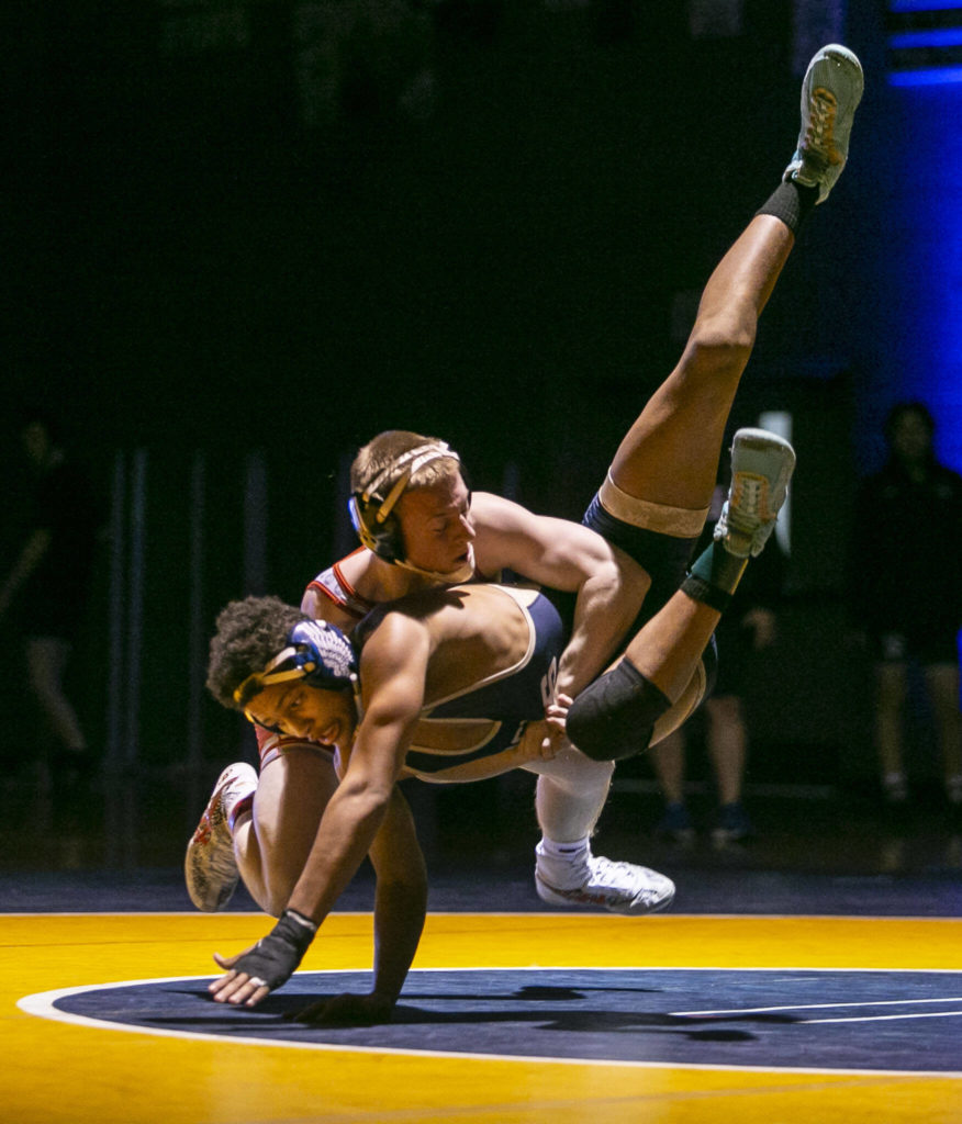 Stanwood’s Tyler Rhue throws Arlington’s Tre Haines during the 145 pound weight class match on Tuesday, Jan. 24, 2023 in Arlington, Washington. (Olivia Vanni / The Herald)
