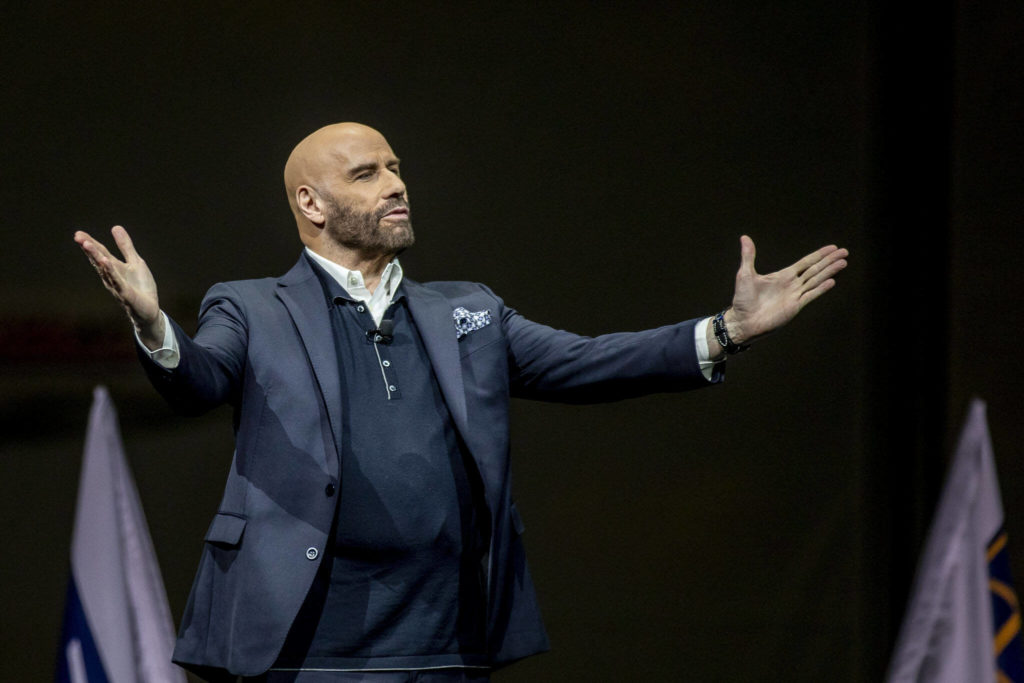 John Travolta speaks during a celebration event on Tuesday, at the 747 factory in Everett. Travolta is a pilot and did the voiceover for the videos on display. (Annie Barker / The Herald)
