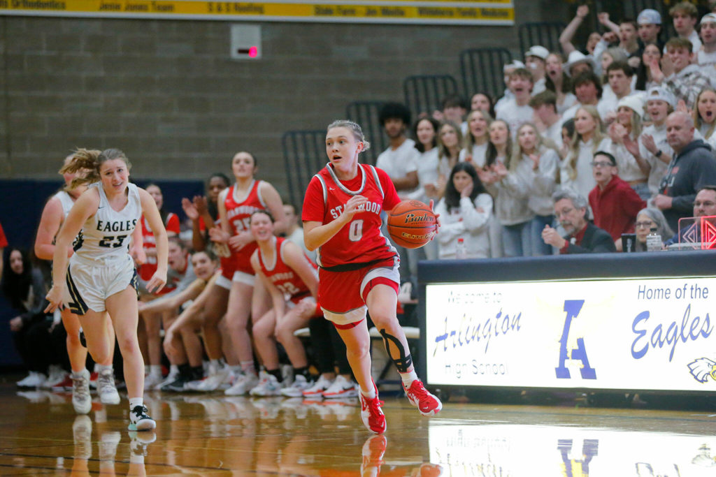 Stanwood’s Grace Walker looks to pass on the fast break before recording an assist against Arlington on Wednesday, Jan. 25, 2023, at Arlington High School in Arlington, Washington. (Ryan Berry / The Herald)
