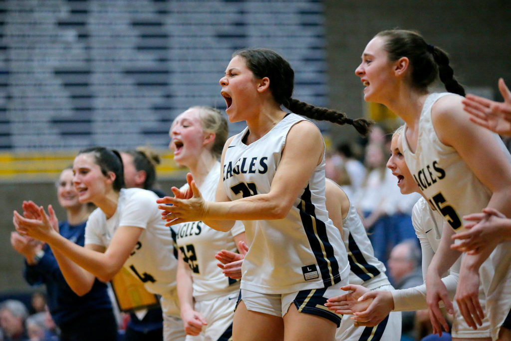 The Arlington bench cheers on their team as they approach a victory over Stanwood on Wednesday, Jan. 25, 2023, at Arlington High School in Arlington, Washington. (Ryan Berry / The Herald)
