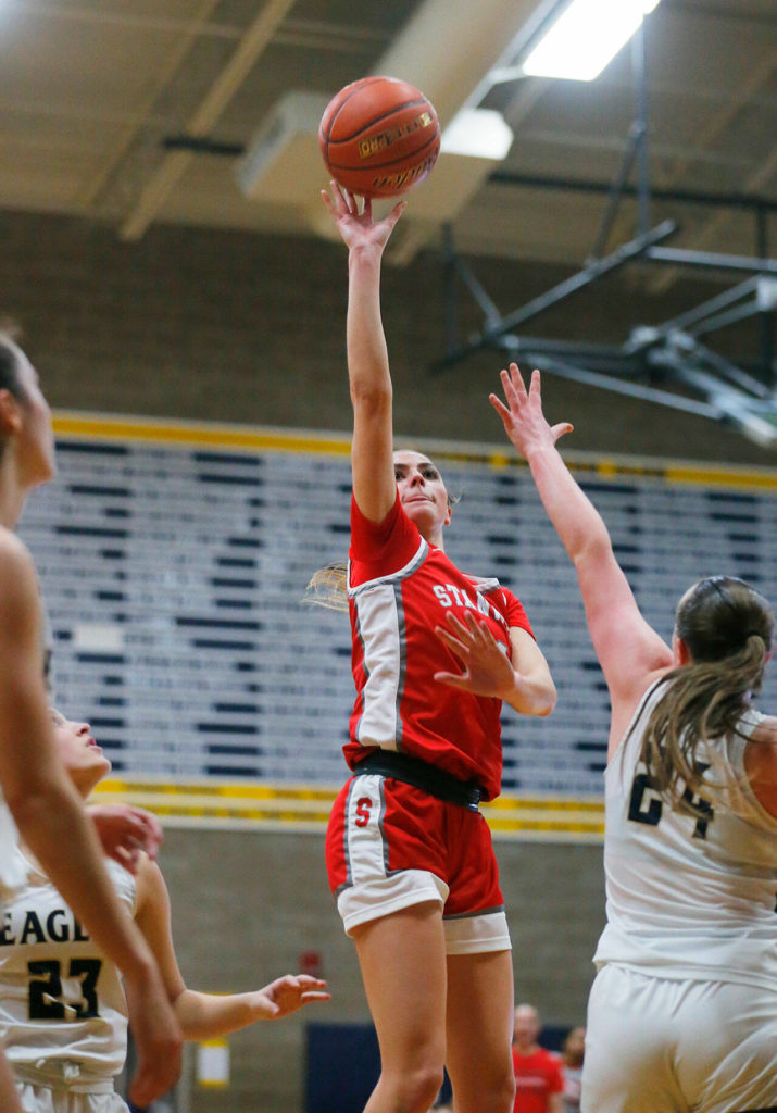 Stanwood’s Tatum Brager tries a floater from medium range against Arlington on Wednesday, Jan. 25, 2023, at Arlington High School in Arlington, Washington. (Ryan Berry / The Herald)
