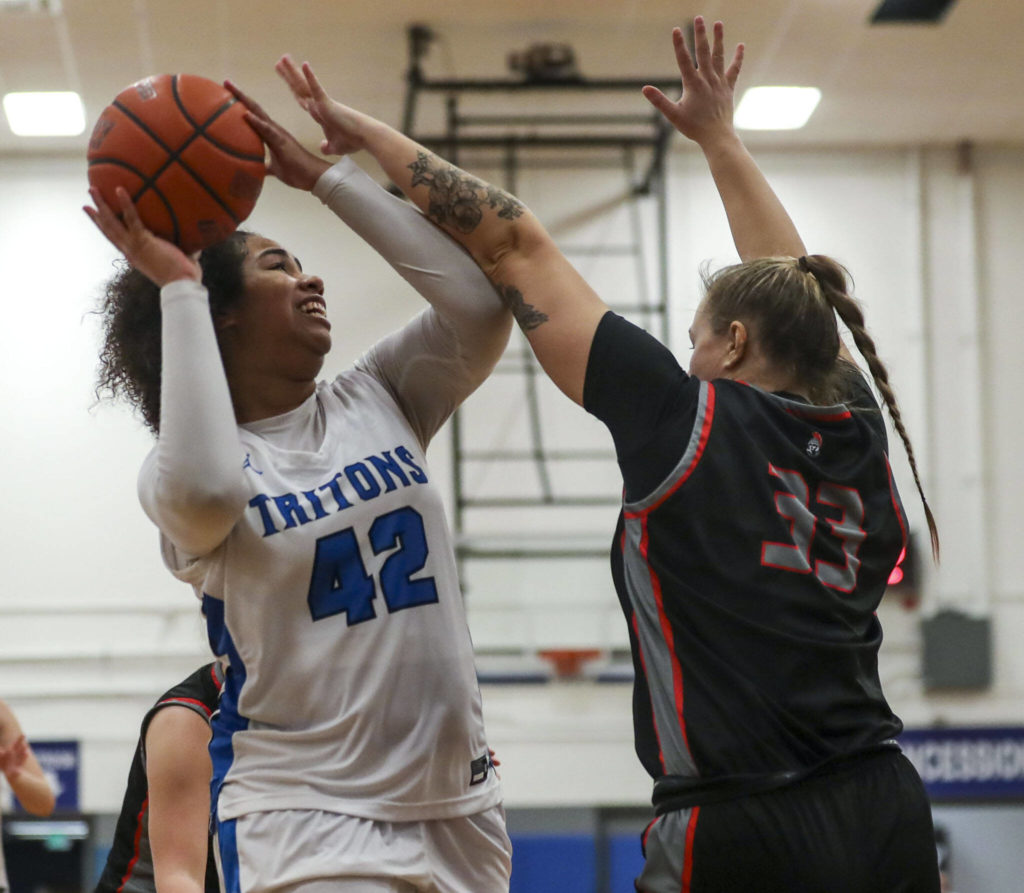 EC’s Layla Young (42) and ECC’s Abbie Juozapatis (33) fight for the ball during a women’s game between the Everett Community College Trojans and Edmonds College Tritons at Seaview Gymnasium at Edmonds College in Lynnwood, Washington on Wednesday Jan. 25, 2023. The Tritons won, 65-52. (Annie Barker / The Herald)
