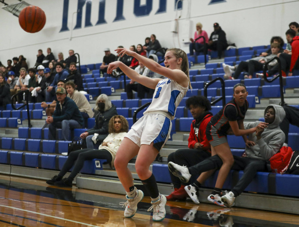 EC’s Raylie Wardenaar (3) shoots the ball as ECC’s Mia Jones (11) falls into a fan during a women’s game between the Everett Community College Trojans and Edmonds College Tritons at Seaview Gymnasium at Edmonds College in Lynnwood, Washington on Wednesday Jan. 25, 2023. The Tritons won, 65-52. (Annie Barker / The Herald)
