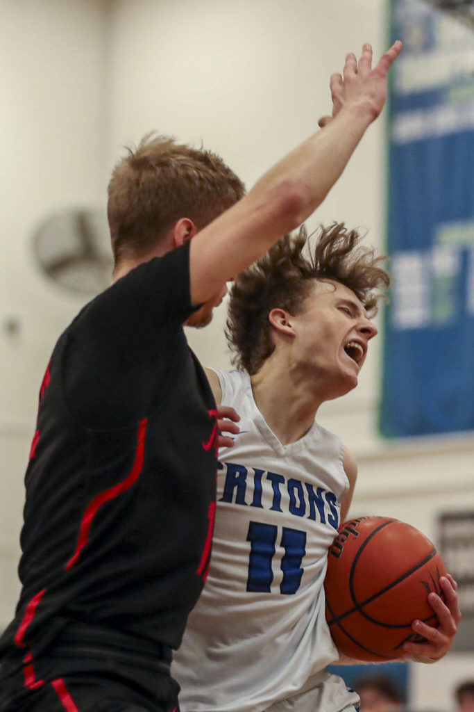 EC’s Caleb Lee (11) fights to keep the ball during a men’s game between the Everett Community College Trojans and Edmonds College Tritons at Seaview Gymnasium at Edmonds College in Lynnwood, Washington on Wednesday Jan. 25, 2023. The Tritons won, 91-84. (Annie Barker / The Herald)
