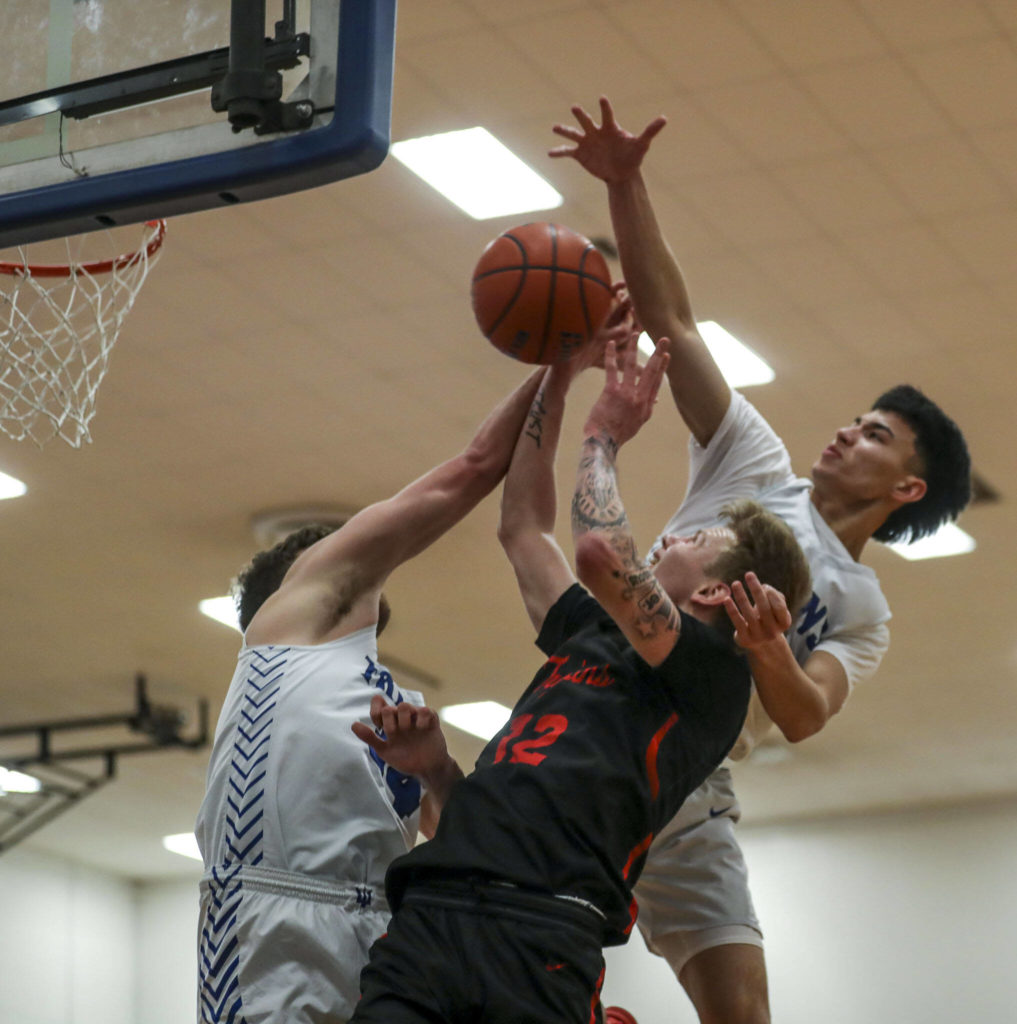 ECC’s Colton Spencer (12) fights to keep control of the ball during a men’s game between the Everett Community College Trojans and Edmonds College Tritons at Seaview Gymnasium at Edmonds College in Lynnwood, Washington on Wednesday Jan. 25, 2023. The Tritons won, 91-84. (Annie Barker / The Herald)
