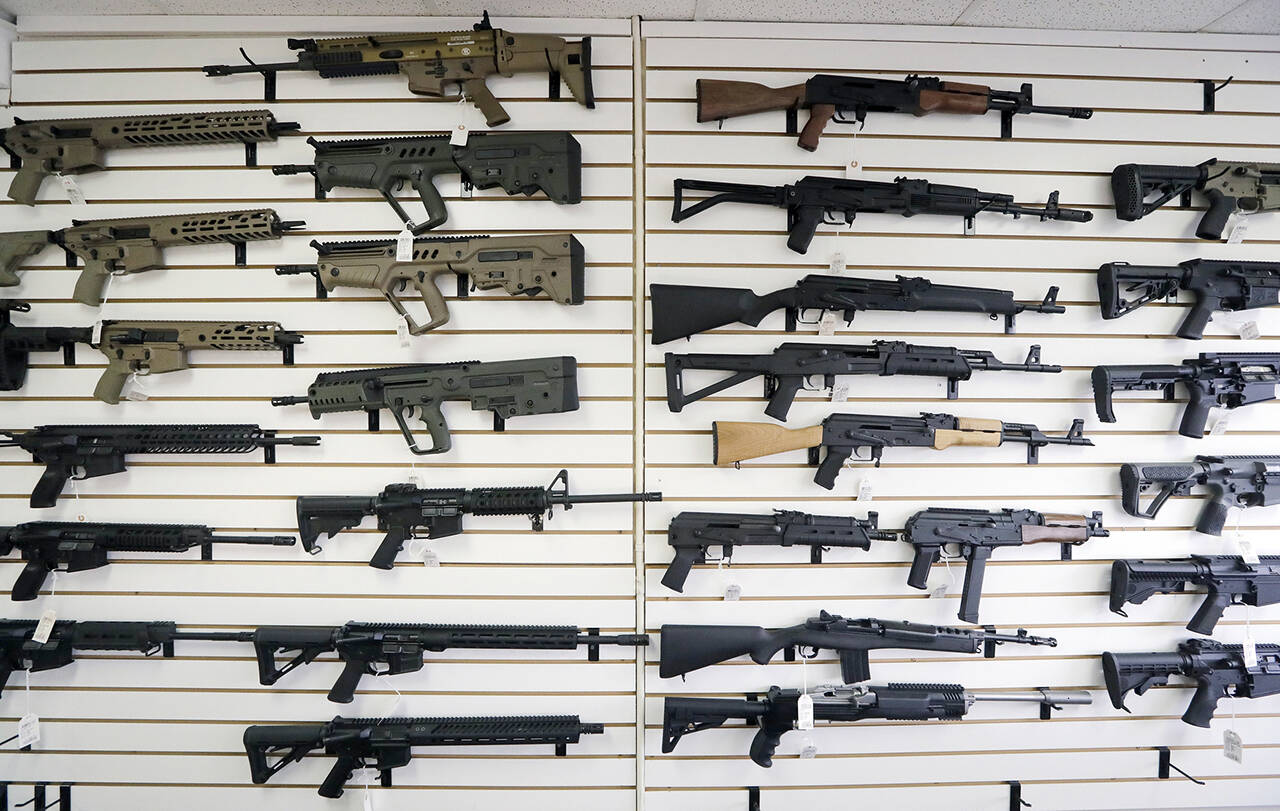 Semi-automatic rifles fill a wall on Oct. 2, 2018 at a gun shop in Lynnwood. (AP Photo/Elaine Thompson, File)