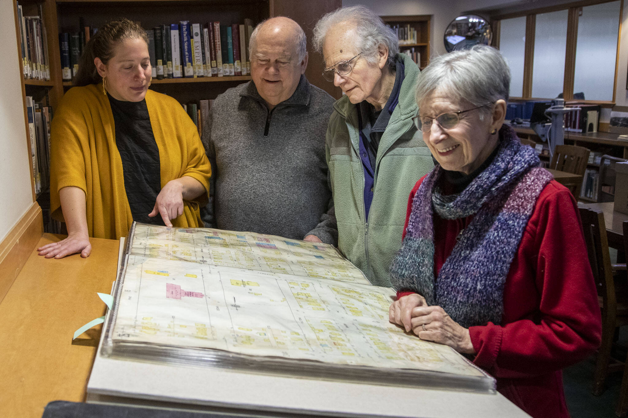 Left to right, Northwest Room Librarian Lisa Labovitch, 41, and contributors to HistoryLink, an online encyclopedia on Washington history, Bob Mayer, 76, David Cameron, 81, and Louise Lindgren, 79, pose for a photo on Jan. 19, at the Everett Public Library. (Annie Barker / The Herald)