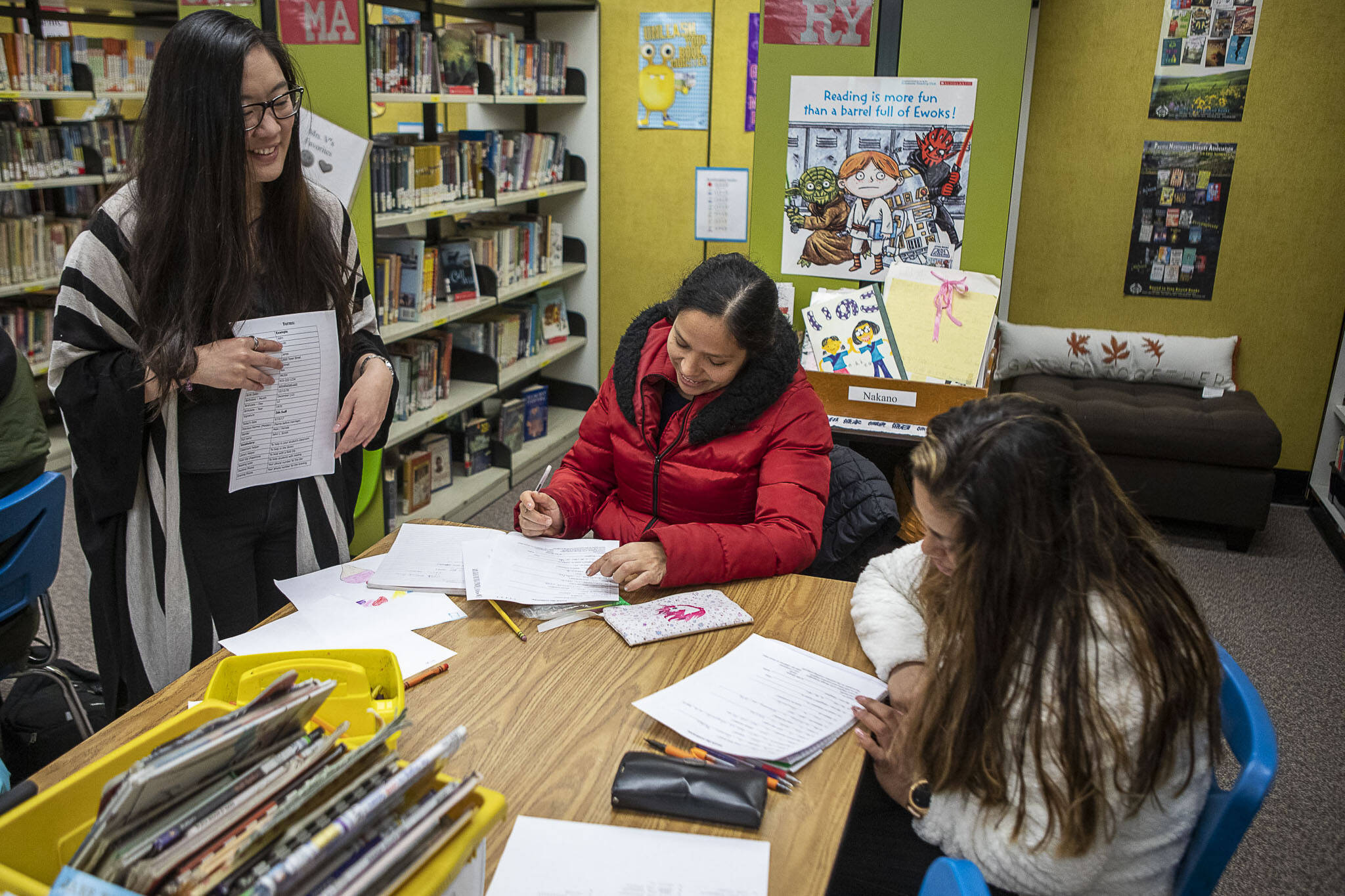 Maricel Pe Samaniego, left, teaches English to Anayeli Granados, center, and Carmen Roldain, right, at Liberty Elementary School on Jan. 30, in Marysville. Marysville schools partners with EvCC to offer free English classes to parents of multi-lingual students. (Annie Barker / The Herald)