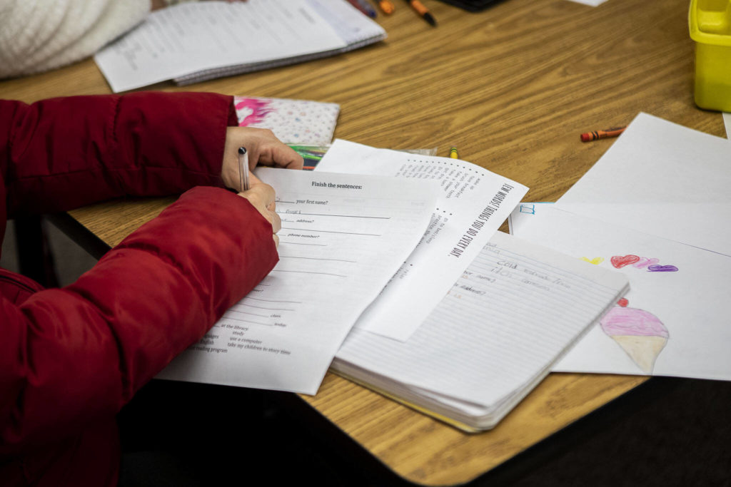 Anayeli Granados completes a worksheet as Maricel Pe Samaniego teaches English at Liberty Elementary School on Jan. 30, in Marysville. Marysville schools partners with EvCC to offer free English classes to parents of multi-lingual students. (Annie Barker / The Herald)
