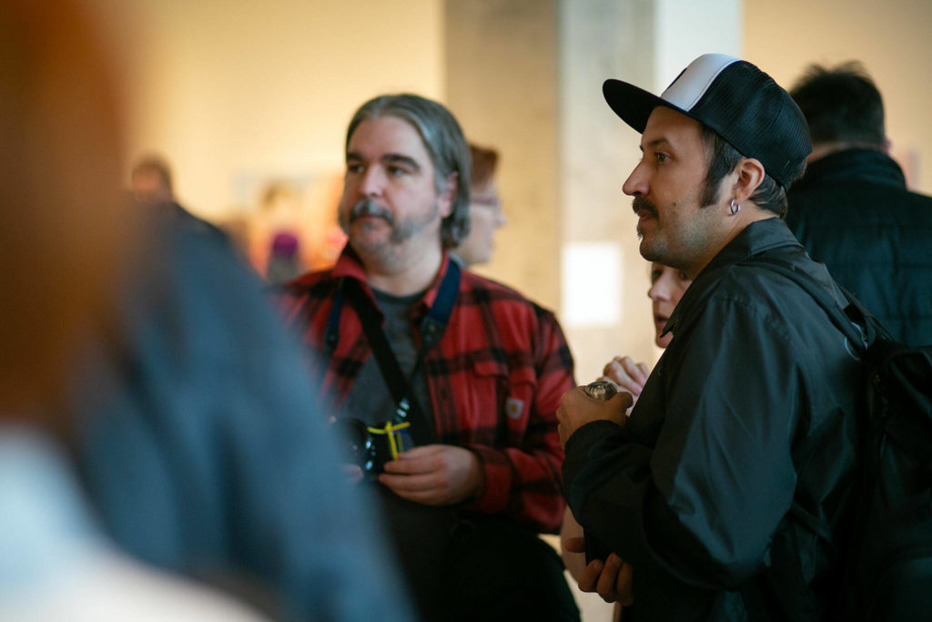 Artist Sashko Danylenko, right, whose art is featured in the gallery, mingles with guests during a public event highlighting the For Ukraine: Art of Freedom exhibit at the Schack Art Center on Saturday, in downtown Everett. (Ryan Berry / The Herald)
