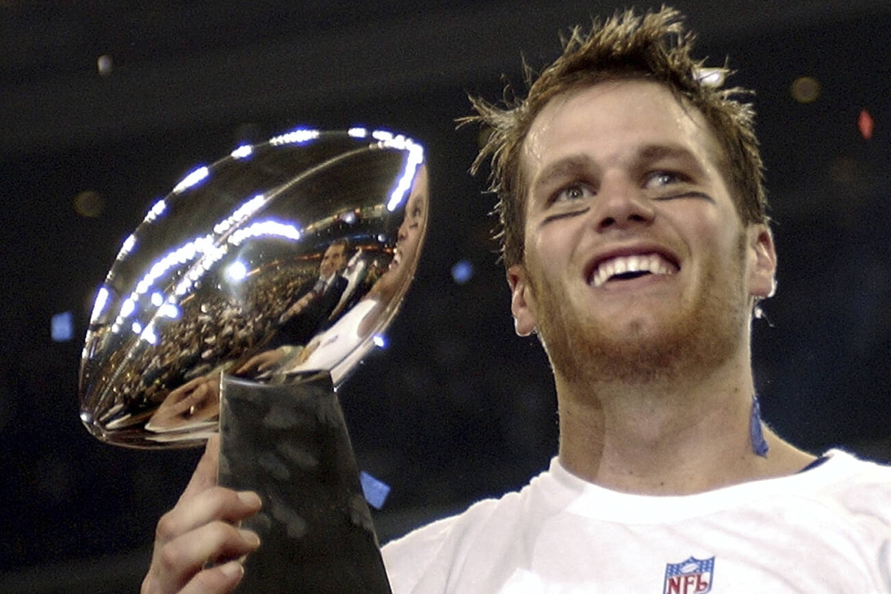 FILE - In this Feb. 1, 2004, file photo, New England Patriots quarterback Tom Brady holds the Vince Lombardi Trophy after the Patriots beat the Carolina Panthers 32-29 in Super Bowl 38 in Houston. Brady, who won a record seven Super Bowls for New England and Tampa, has announced his retirement, Wednesday, Feb. 1, 2023.  (AP Photo/Dave Martin, File)
