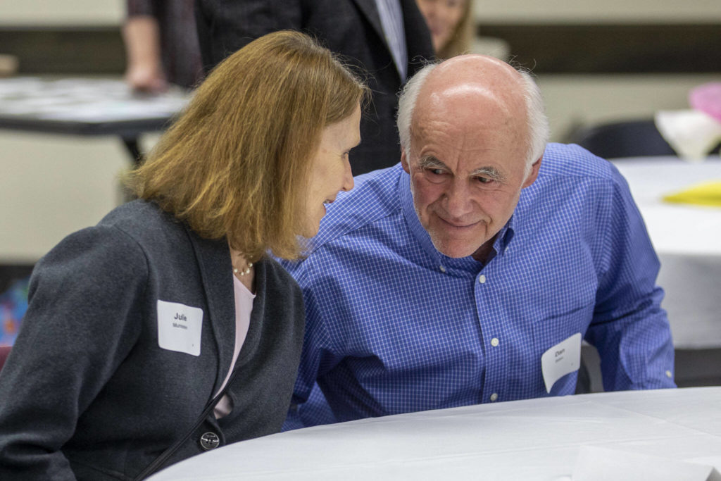 Julie Muhlstein, left, and Dan Bates, right, talk together as they are recognized by the Everett Museum of History for their contributions as longtime former Herald journalists at the museum’s annual fundraiser at the Henry M. Jackson Conference Center in Everett, Washington on Sunday, Feb. 26, 2023. (Annie Barker / The Herald)
