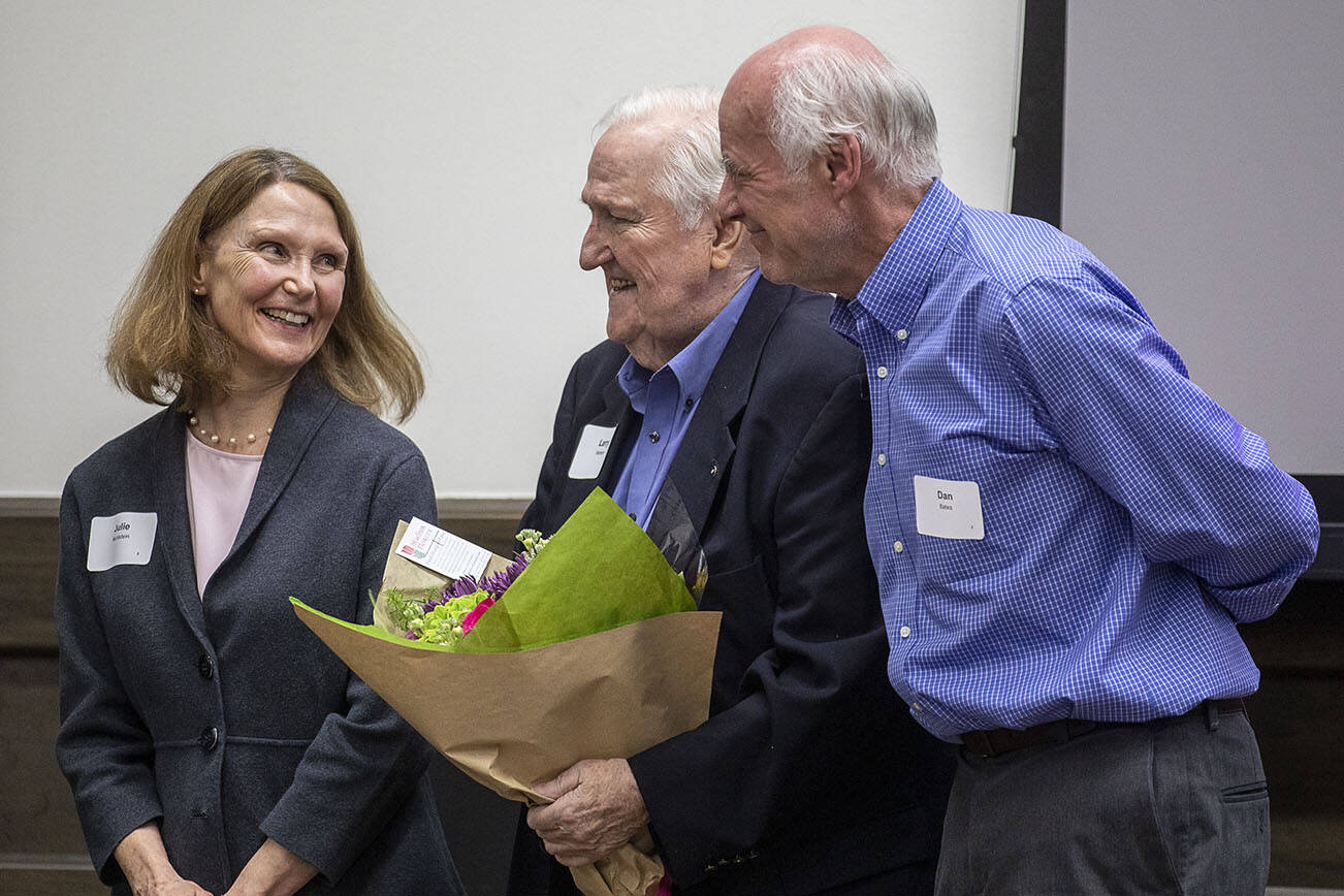 Julie Muhlstein, left, and Dan Bates, right, receive congratulations from Larry Hanson, center, as they are recognized by the Everett Museum of History for their contributions as longtime former Herald journalists at the museum’s annual fundraiser at the Henry M Jackson Conference Center in Everett, Washington on Sunday, Feb. 26, 2023. (Annie Barker / The Herald)