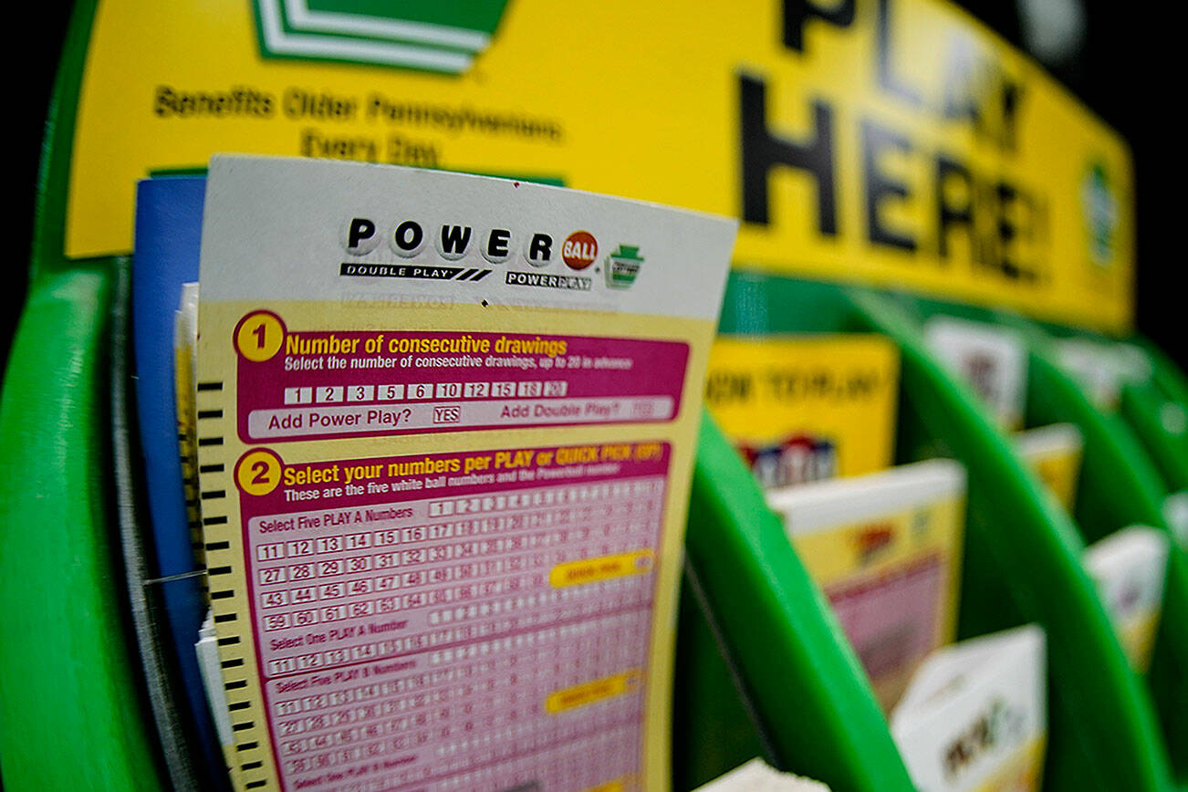A rack with cards bettors can use to choose their own numbers to purchase lottery ticket on a counter at a market. (AP Photo/Keith Srakocic)