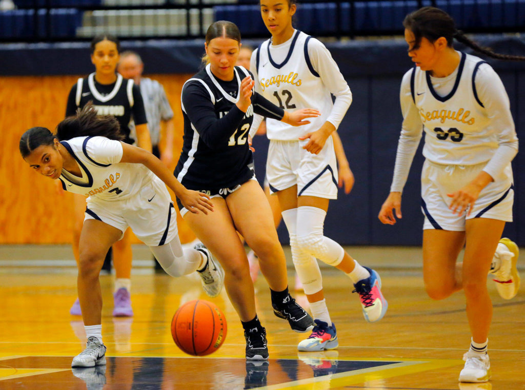 Lynnwood’s Nyree Johnson chases down a loose ball while being guarded by multiple defenders against Everett on Thursday, Dec. 15, 2022, at Norm Lowery Gymnasium in Everett, Washington. (Ryan Berry / The Herald)
