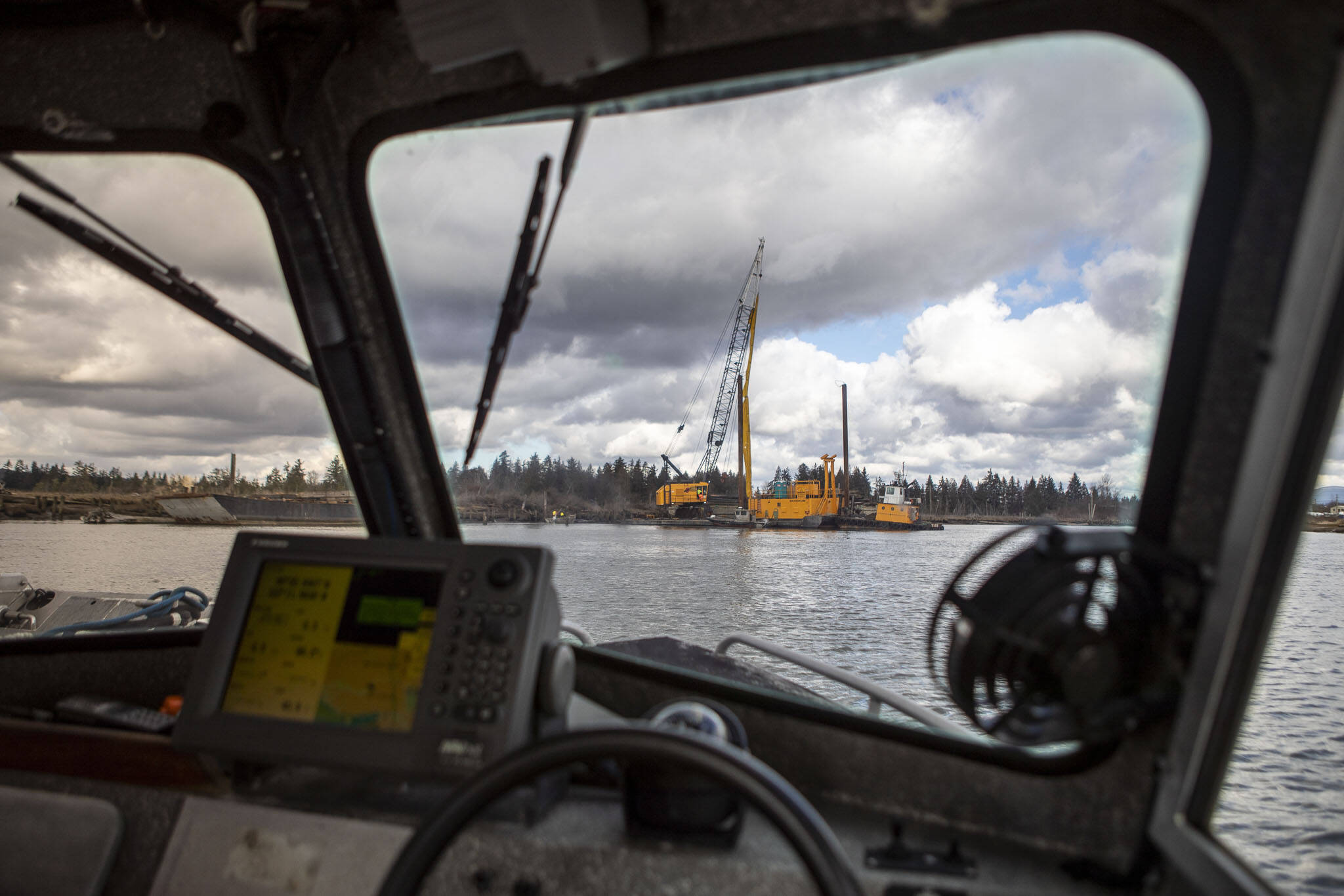 A team works to remove old toxic pilings from the water as part of larger salmon restoration plan near Ebey Waterfront Park on Feb. 10 in Marysville. (Annie Barker / The Herald)