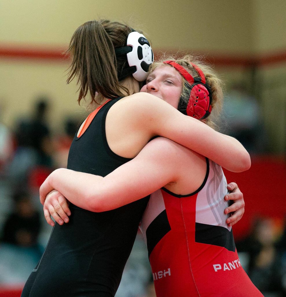 Frances Porteous and Jillian Hradec hug after Porteous’s victory over Hradec during the 3A/4A Girls Region 1 Wrestling Tournament on Saturday, Feb. 11, 2023, at Snohomish High School in Snohomish, Washington. (Ryan Berry / The Herald)
