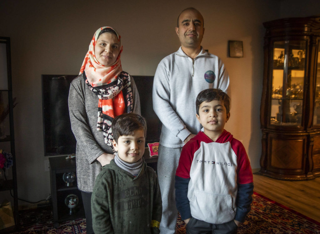 Mohammad Zamir Omar, right, with his wife Ayasha Omar, left, and two of their four sons Zakariya, 8, and Yousuf, 6, at their home on Tuesday, in Lynnwood. (Olivia Vanni / The Herald) 
