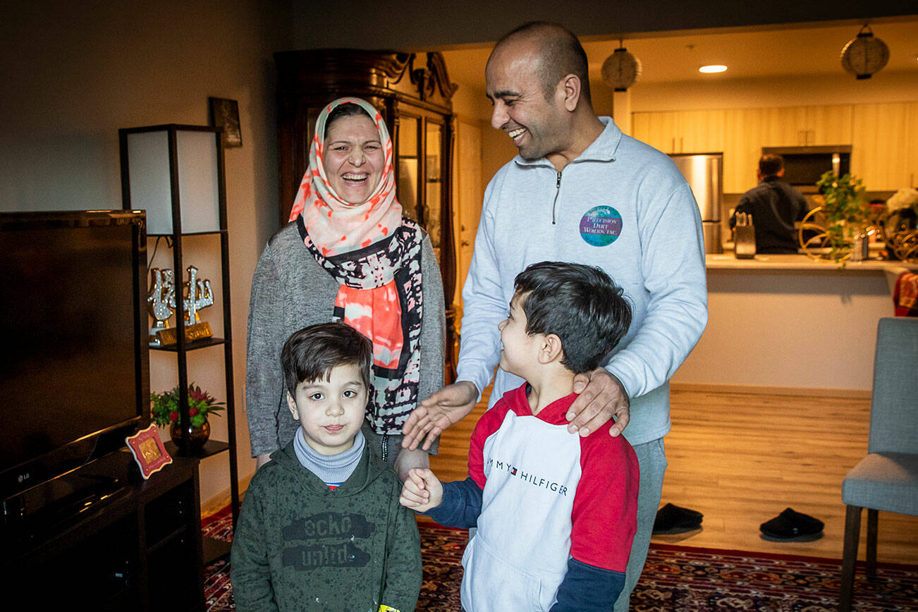 Mohammad Zamir Omar, right, with his wife Ayasha Omar, left, and two of their four sons Zakariya, 8, and Yousuf, 6, at their home on Tuesday, Feb. 14, 2023 in Lynnwood, Washington. (Olivia Vanni / The Herald)