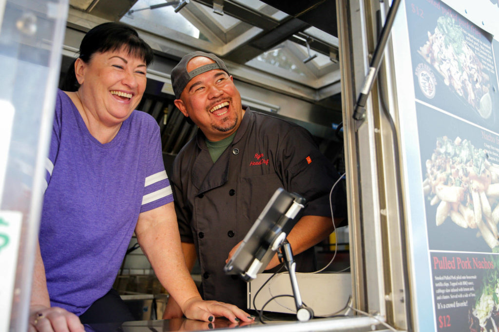 Cindy Montgomery with her son, Ryan Gobin, owner of Ryan’s REZ-ipes, laugh at the antics of patron Friday afternoon at Skookum Brewery in Arlington on October 14, 2022. (Kevin Clark / The Herald)
