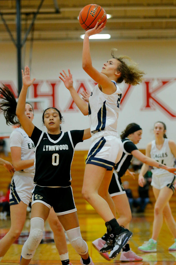 Arlington’s Samara Morrow puts up a floater against Lynnwood on Tuesday, Feb. 14, 2023, at Marysville Pilchuck High School in Marysville, Washington. (Ryan Berry / The Herald)
