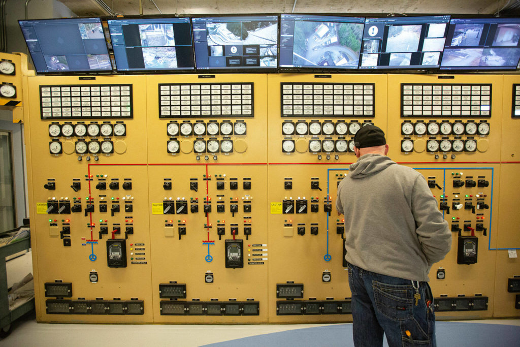 A Henry M. Jackson Powerhouse employee looks at the “GE cabinet,” a manual control board for the different generators, Friday near Sultan. (Ryan Berry / The Herald)
