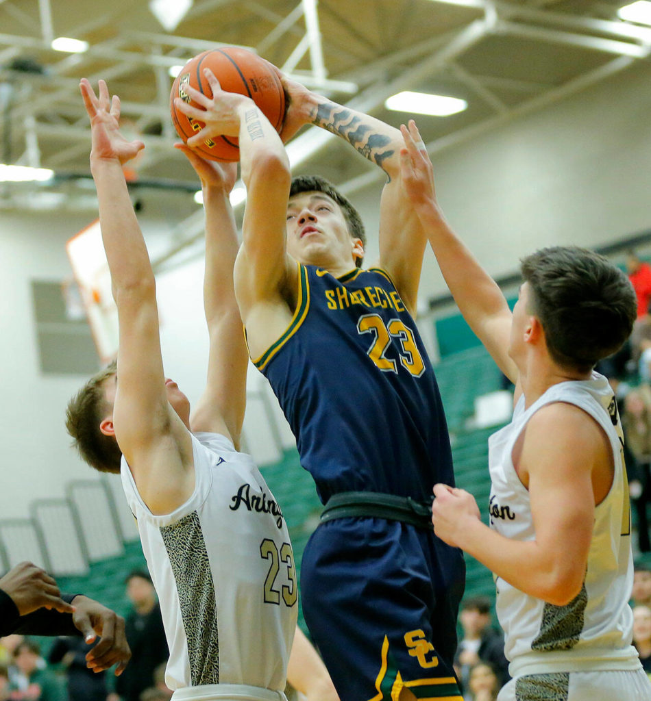 Shorecrest’s Parker Baumann draws a shooting foul against Arlington on Wednesday, Feb. 15, 2023, at Jackson High School in Mill Creek, Washington. (Ryan Berry / The Herald)
