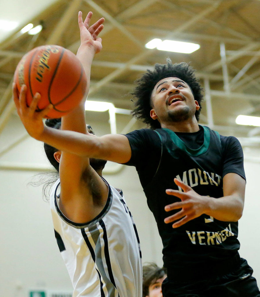 Mount Vernon’s Michael Johnson tries to finish a shot after a mid-air adjustment against Mountlake Terrace on Wednesday, Feb. 15, 2023, at Jackson High School in Mill Creek, Washington. (Ryan Berry / The Herald)
