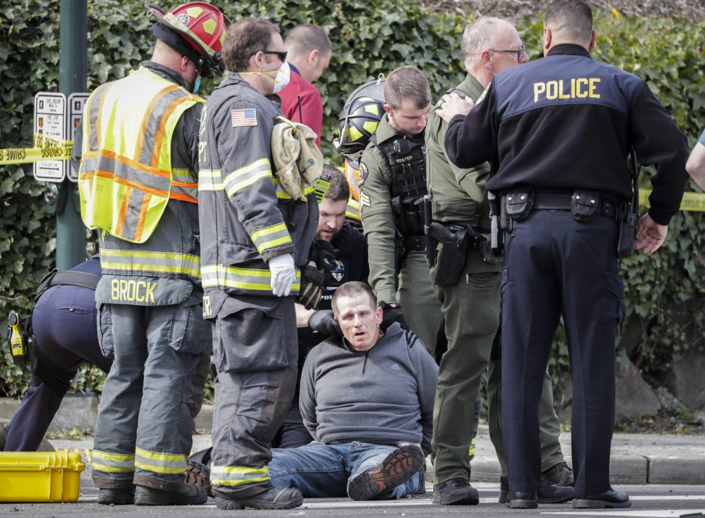 A suspect in the shooting of Everett police officer Dan Rocha is held at 35th and Rucker Ave after a three car accident in Everett, Washington on March 25, 2022. The suspect was later identified as Richard Rotter and charged with first-degree aggravated murder, second-degree unlawful possession of a firearm, and possession of a controlled substance with intent to manufacture or deliver. Rotter is being held without bail, and is awaiting trial after pleading not guilty to all three chargers. (Kevin Clark / The Herald)
