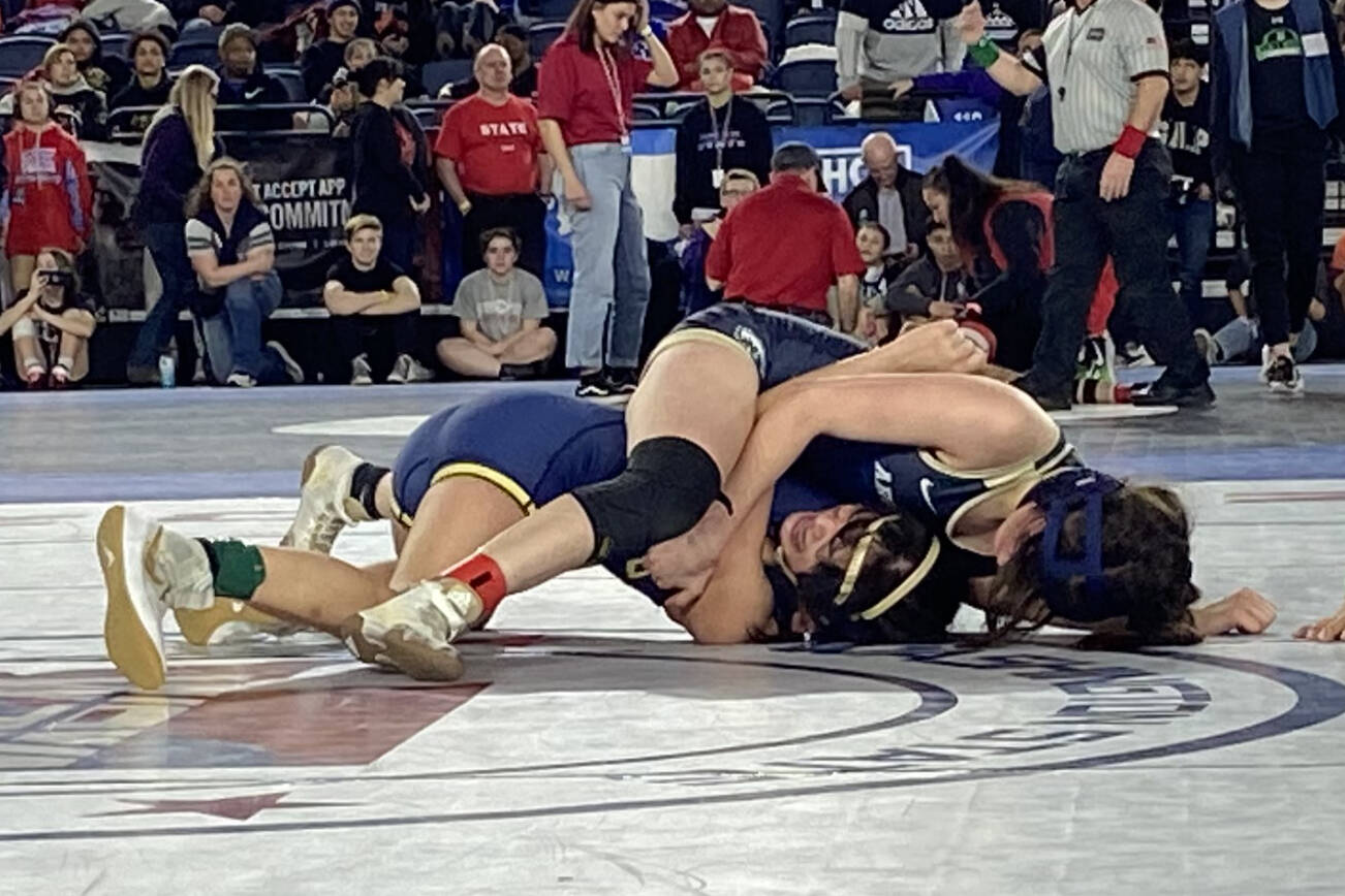 Arlington's Danielle Crew (top) wrestles Kelso's Bella Victoriano in the quarterfinals of the 4A/3A girls 115-pound weight class during the first day of Mat Classic XXXIV on Feb. 17, 2023, at the Tacoma Dome. Crew won by pinfall to reach the state semifinals. (Zac Hereth / The Herald)