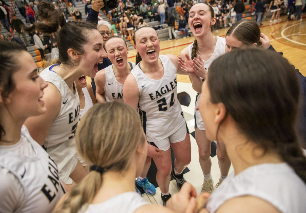 Arlignton players yell in celebration of becoming the 3A District 1 champions on Saturday, Feb. 18, 2023 in Everett, Washington. (Olivia Vanni / The Herald)
