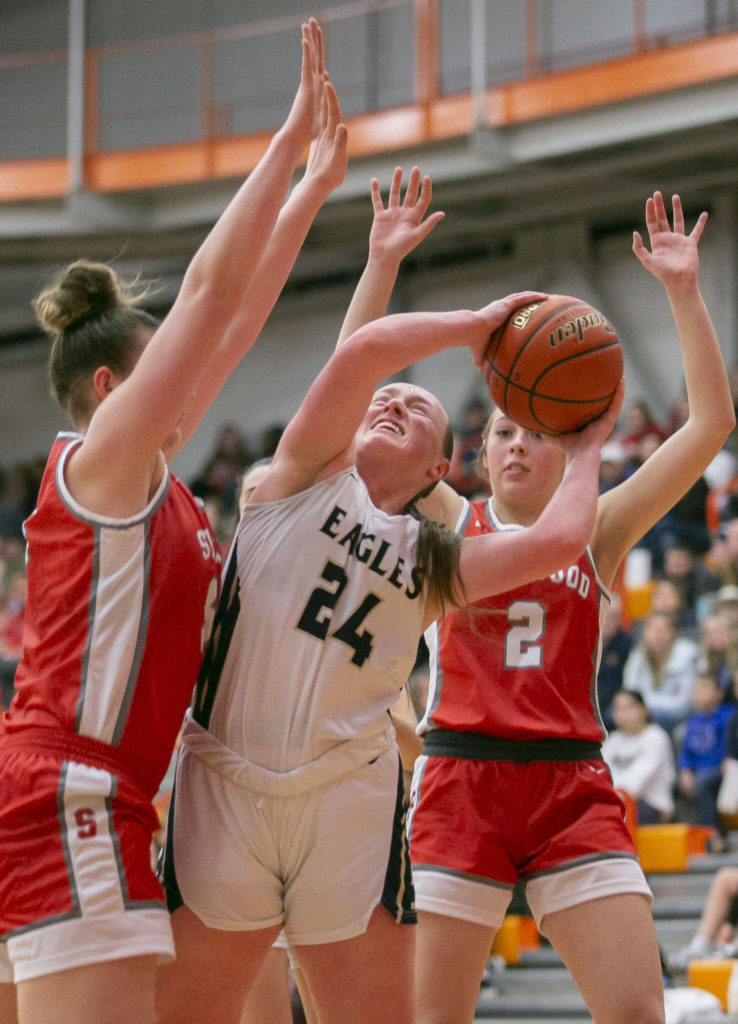 Arlington’s Katie Snow attempts a layup while double guarded during the game against Stanwood on Saturday, Feb. 18, 2023 in Everett, Washington. (Olivia Vanni / The Herald)
