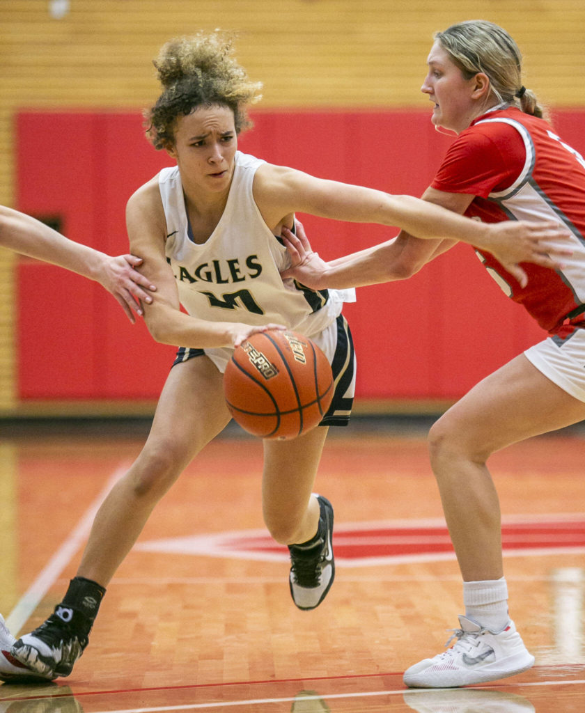 Arlington’s Samara Morrow is pushed as she drives to the hoop during the game against Stanwood on Saturday, Feb. 18, 2023 in Everett, Washington. (Olivia Vanni / The Herald)
