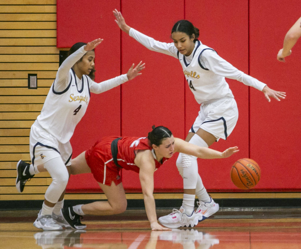 Snohomish’s Jada Andresen is tripped while being double guarded during the game against Everett on Saturday, Feb. 18, 2023 in Everett, Washington. (Olivia Vanni / The Herald)
